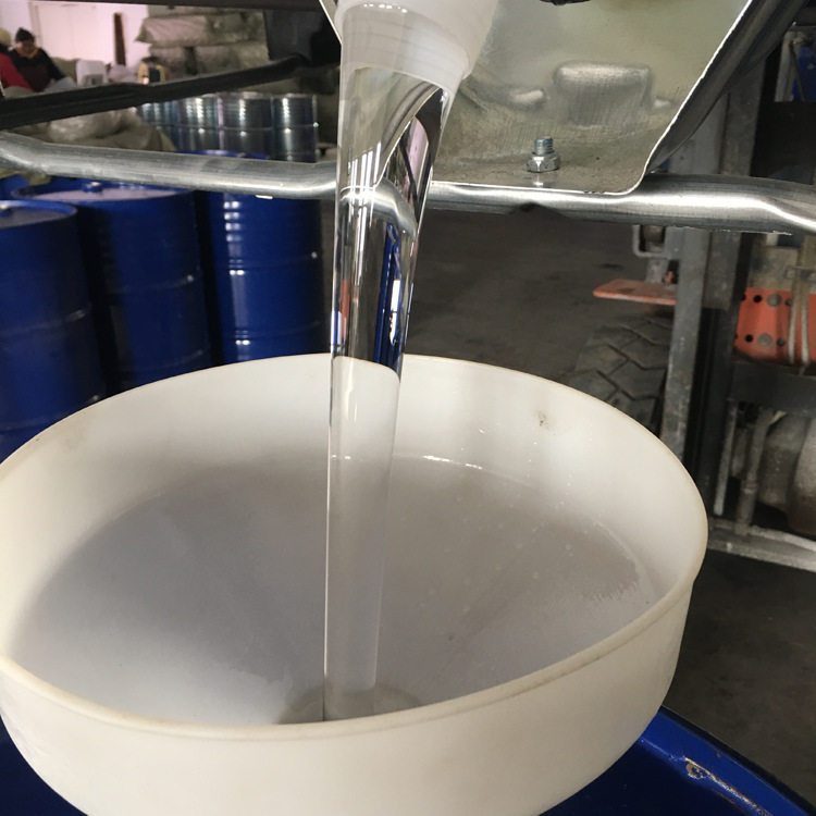 Clear triacetin liquid being poured into a container for inspection